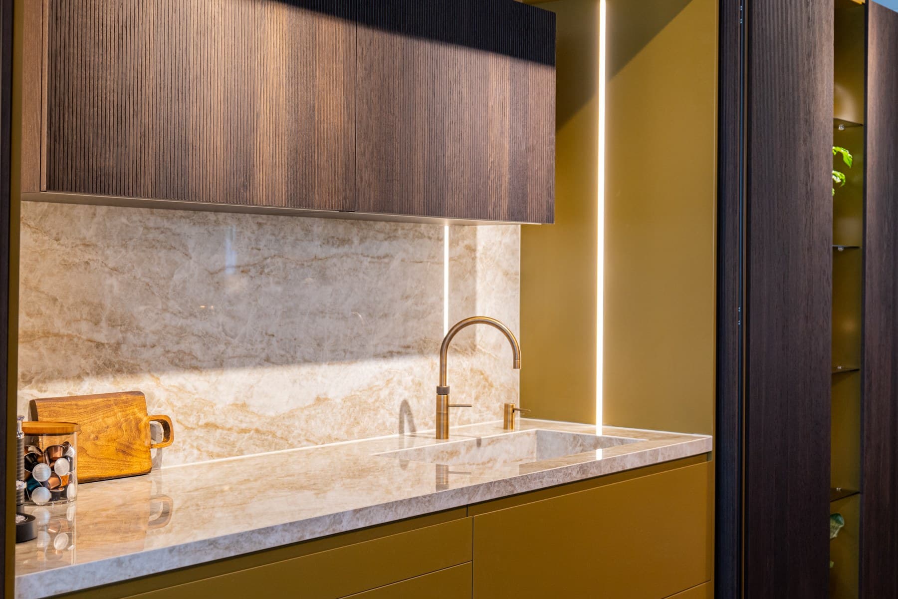 Kitchen with timber cabinetry, pale veined worktop and matching splashback