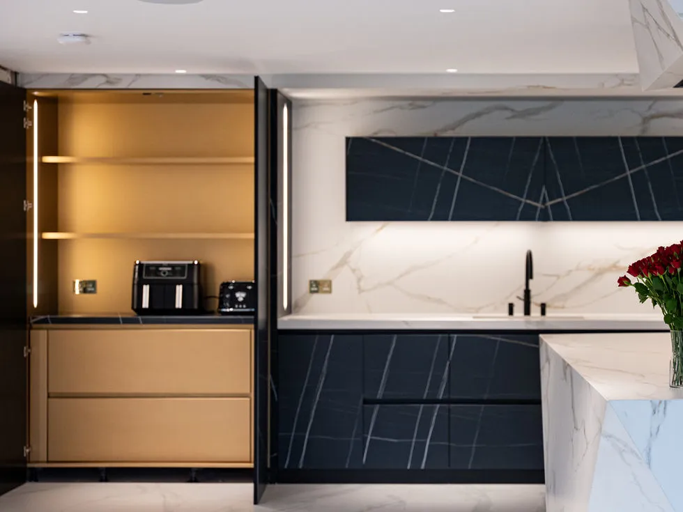 Dark veined cabinetry and warm metallic storage in the Amersham Road kitchen.