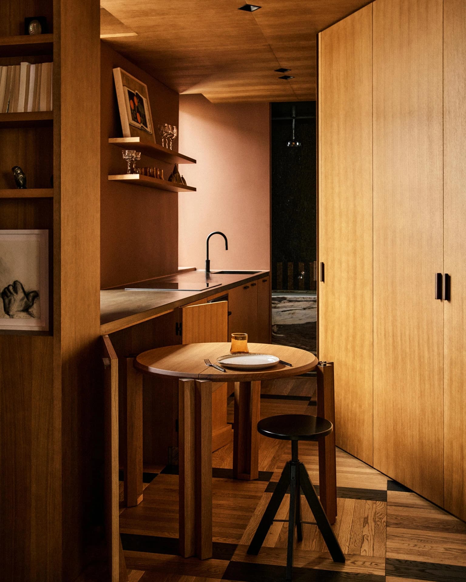 Timber kitchen and small dining area with stools and open shelving