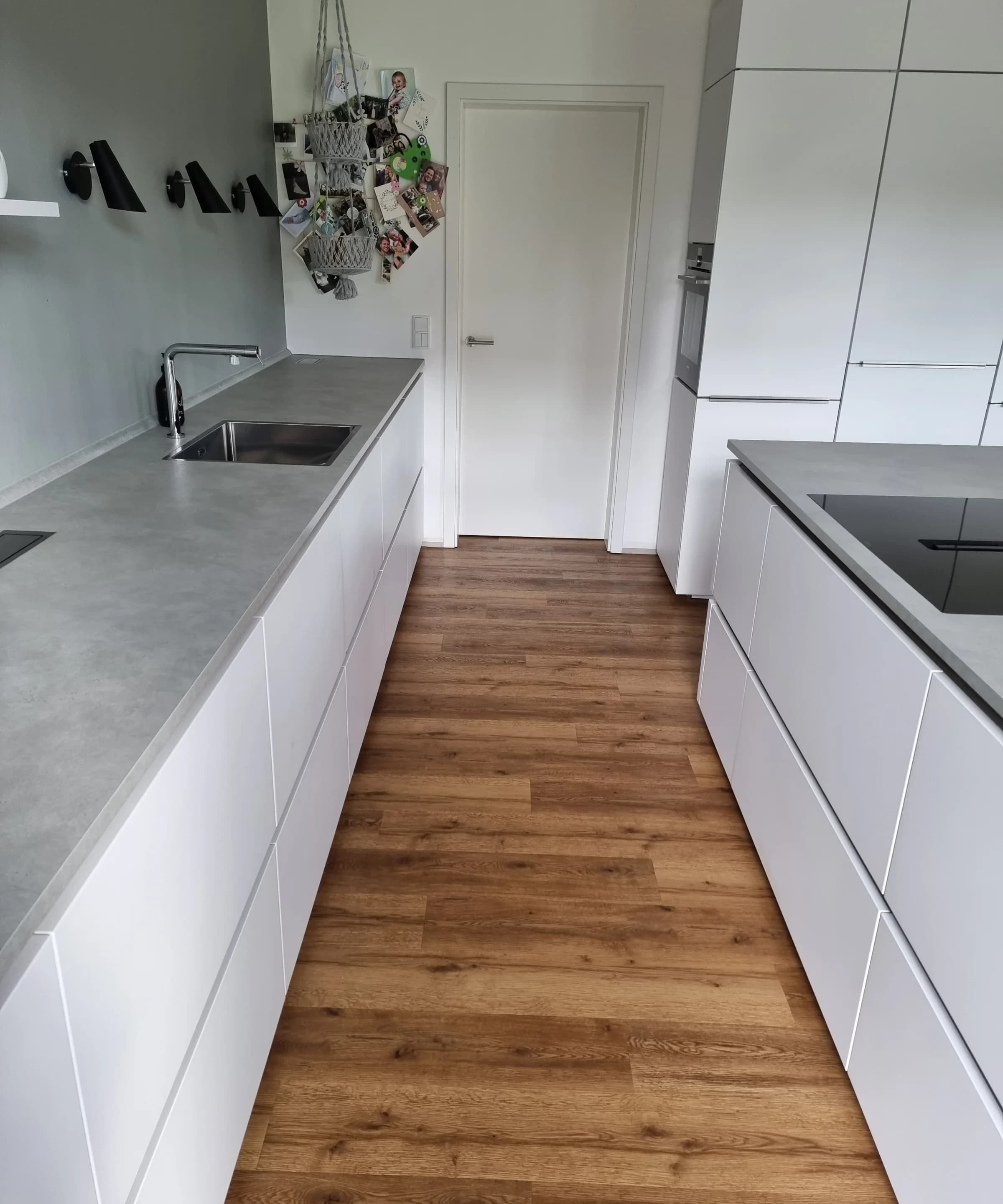 White kitchen cabinets with a recessed plinth and timber flooring