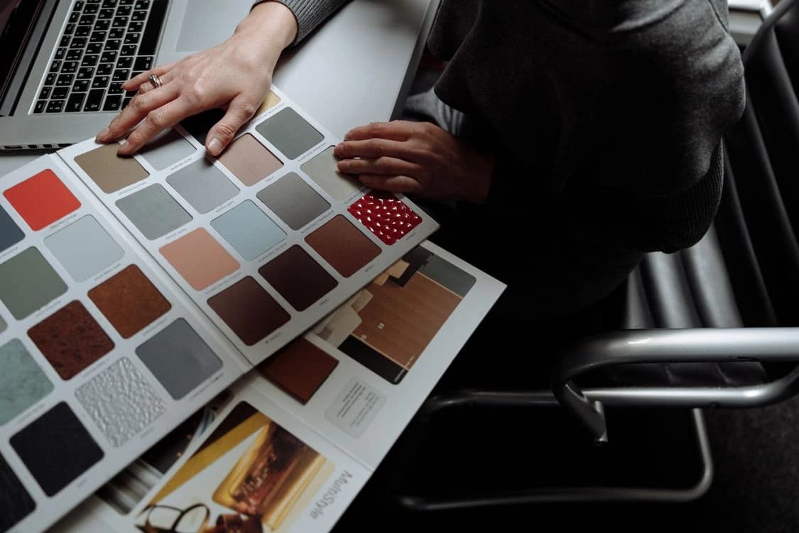 People reviewing a colour fan beside a laptop