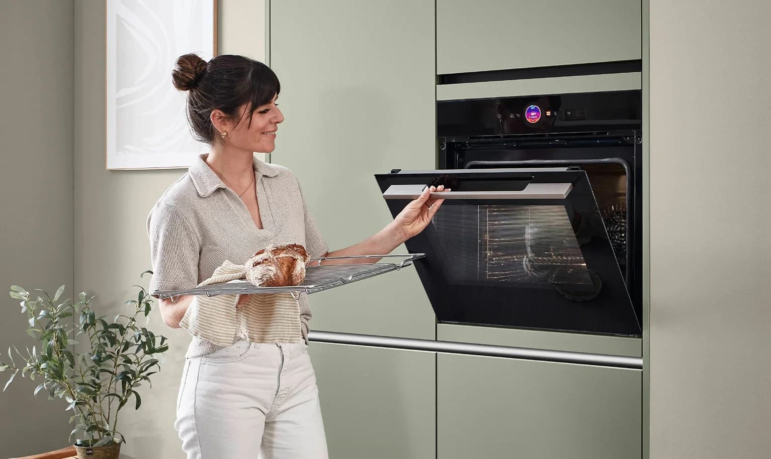 Person opening an integrated oven in a kitchen