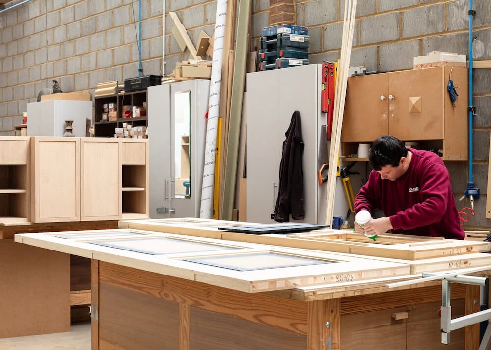 Person assembling a cabinet on a workshop bench