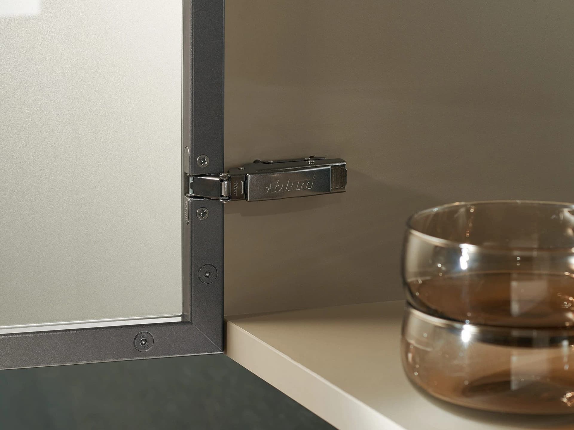 Dark concealed hinge on an open cabinet door