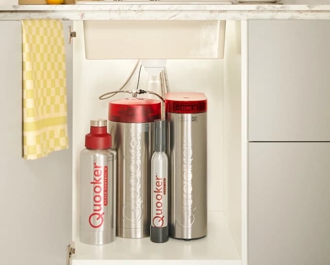 Two cylindrical tap tanks inside a sink cabinet
