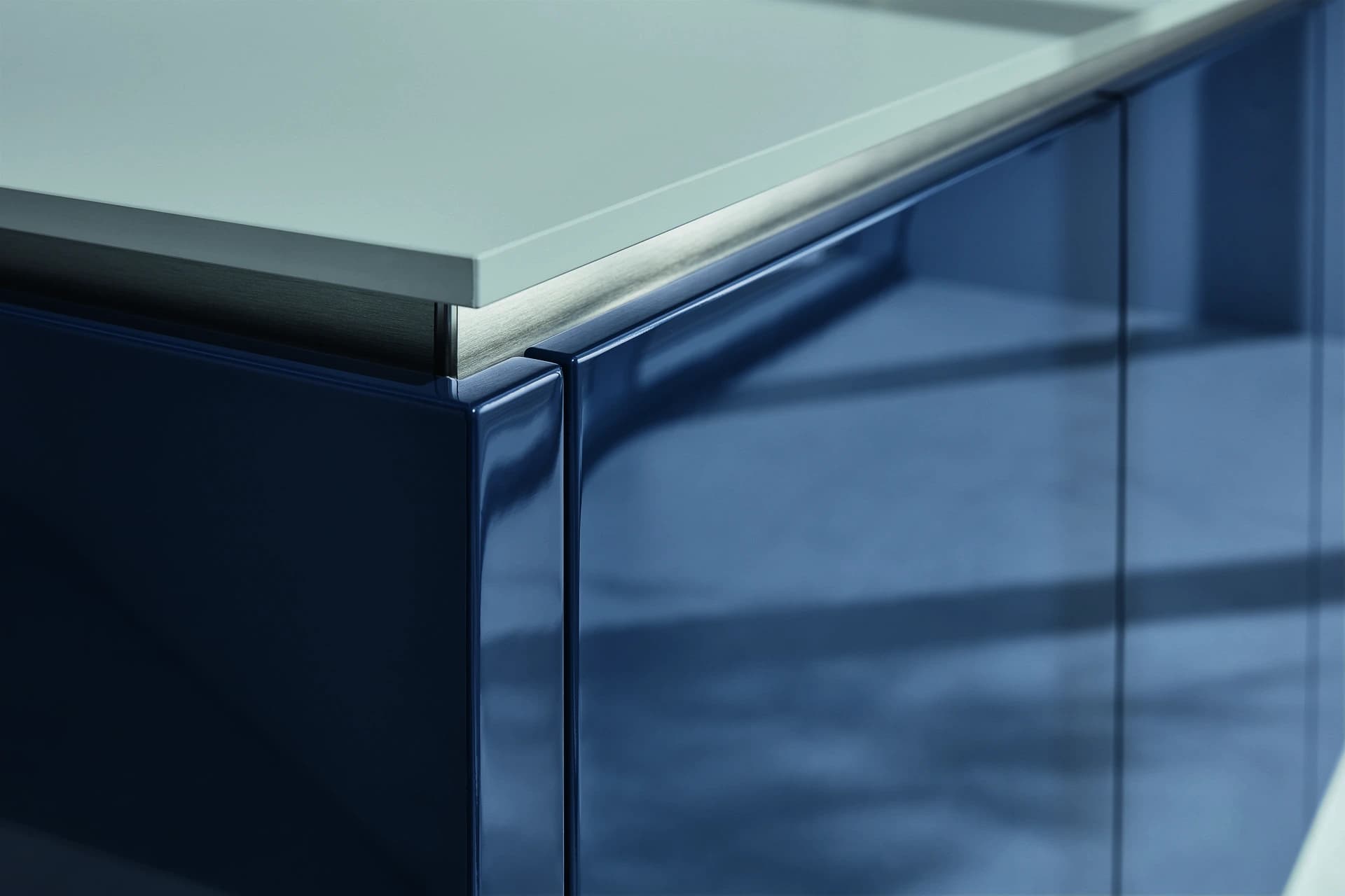 Close view of a glossy blue cabinet front and handle