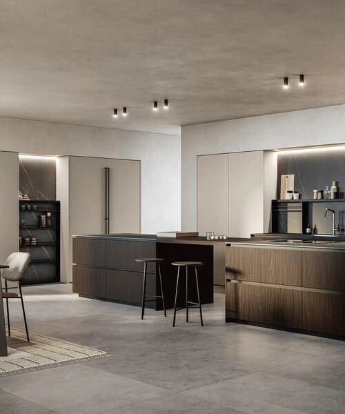 Kitchen island with a dark worktop and tall cupboards behind