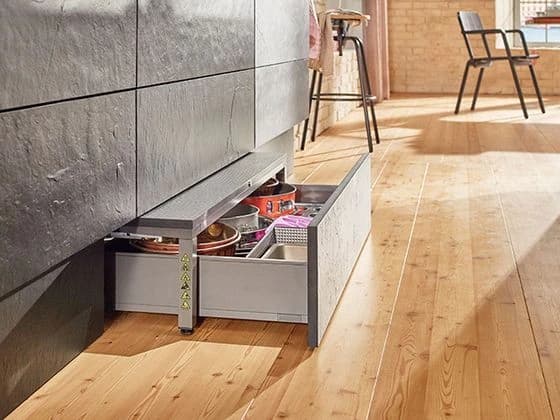 Shallow drawer open beneath kitchen base cabinets