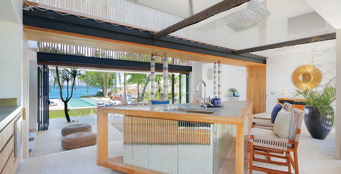 Kitchen island and timber stools beside broad open windows