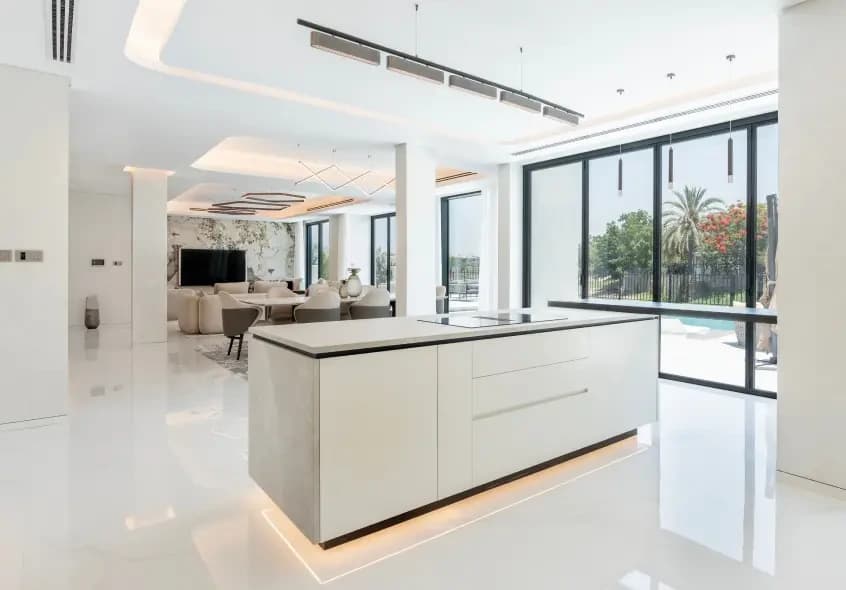 Pale kitchen island and built-in cabinetry in a bright room