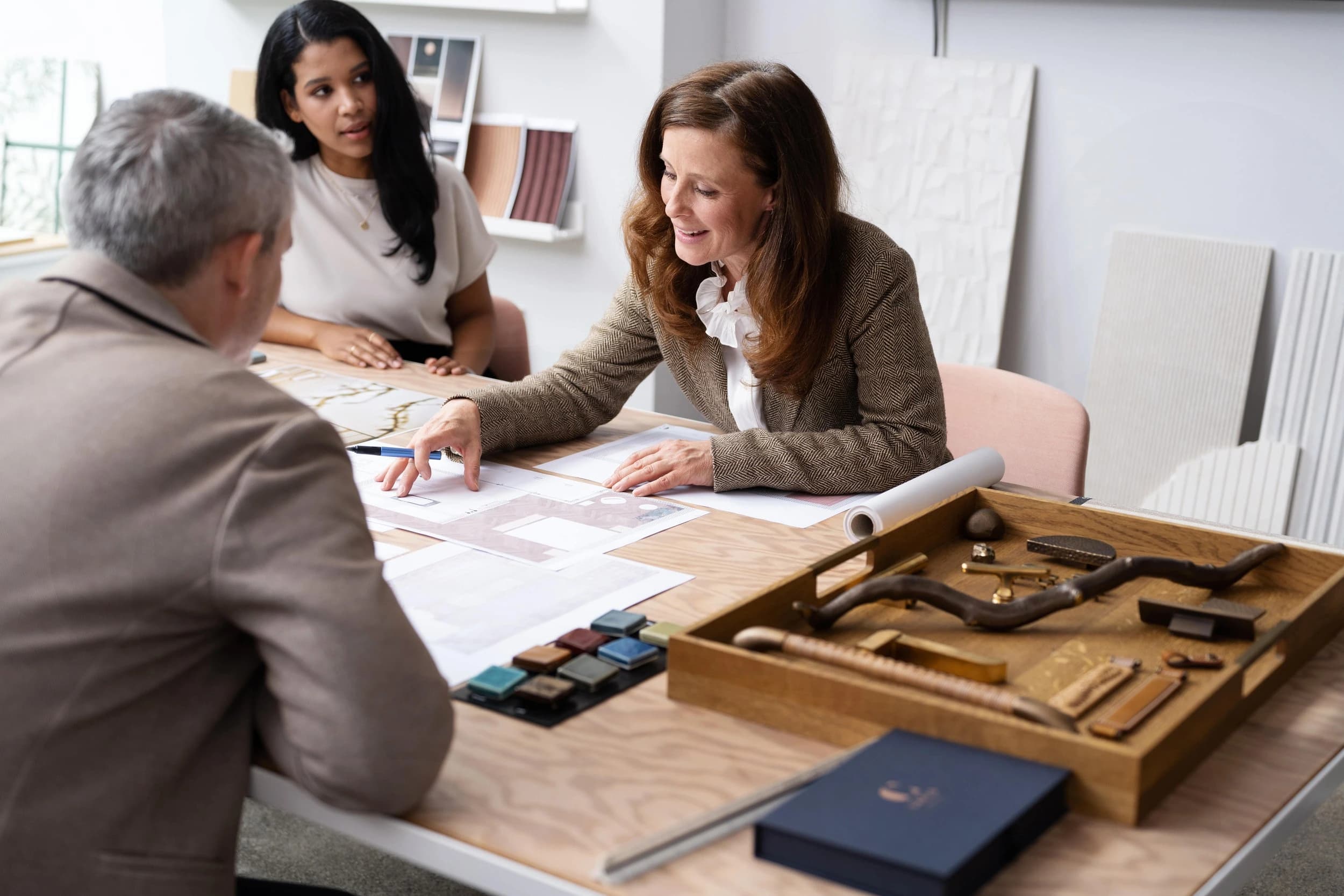 People discussing kitchen plans and cabinet fittings at a table