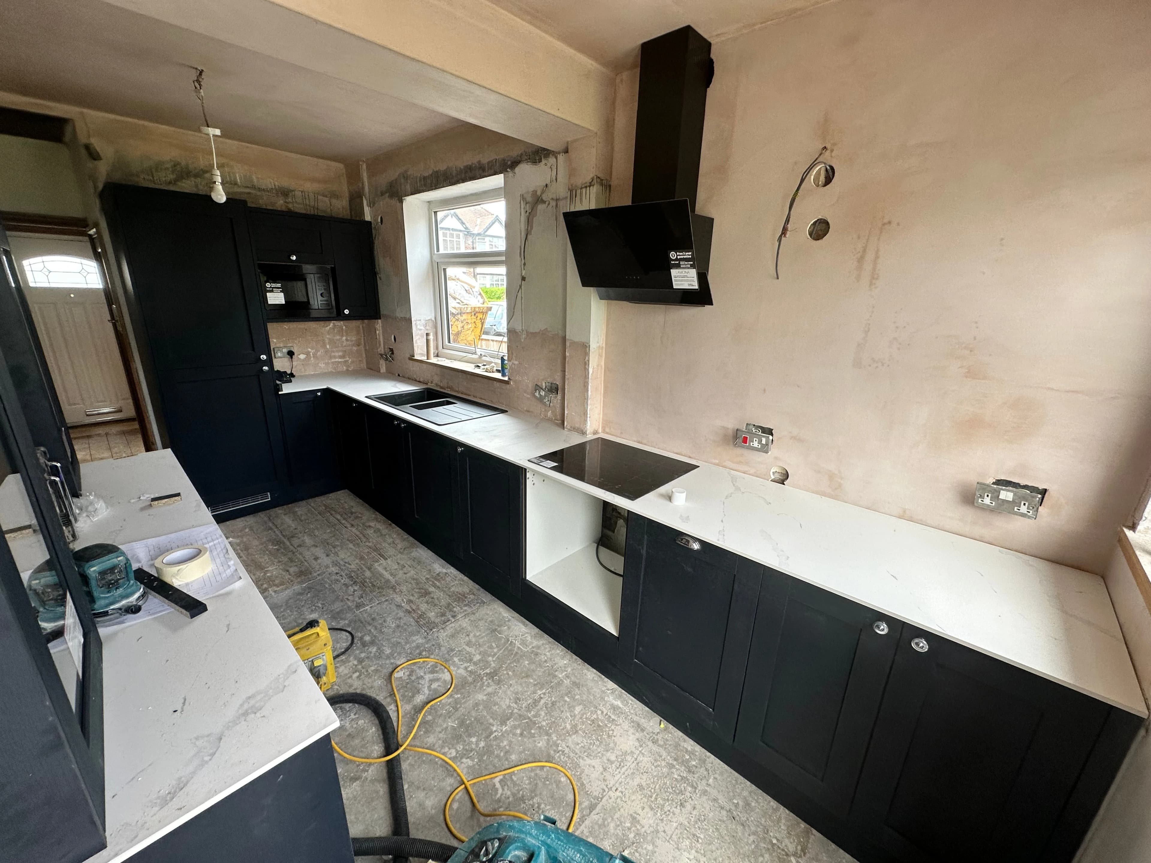 Kitchen cabinets during renovation with unfinished walls and flooring