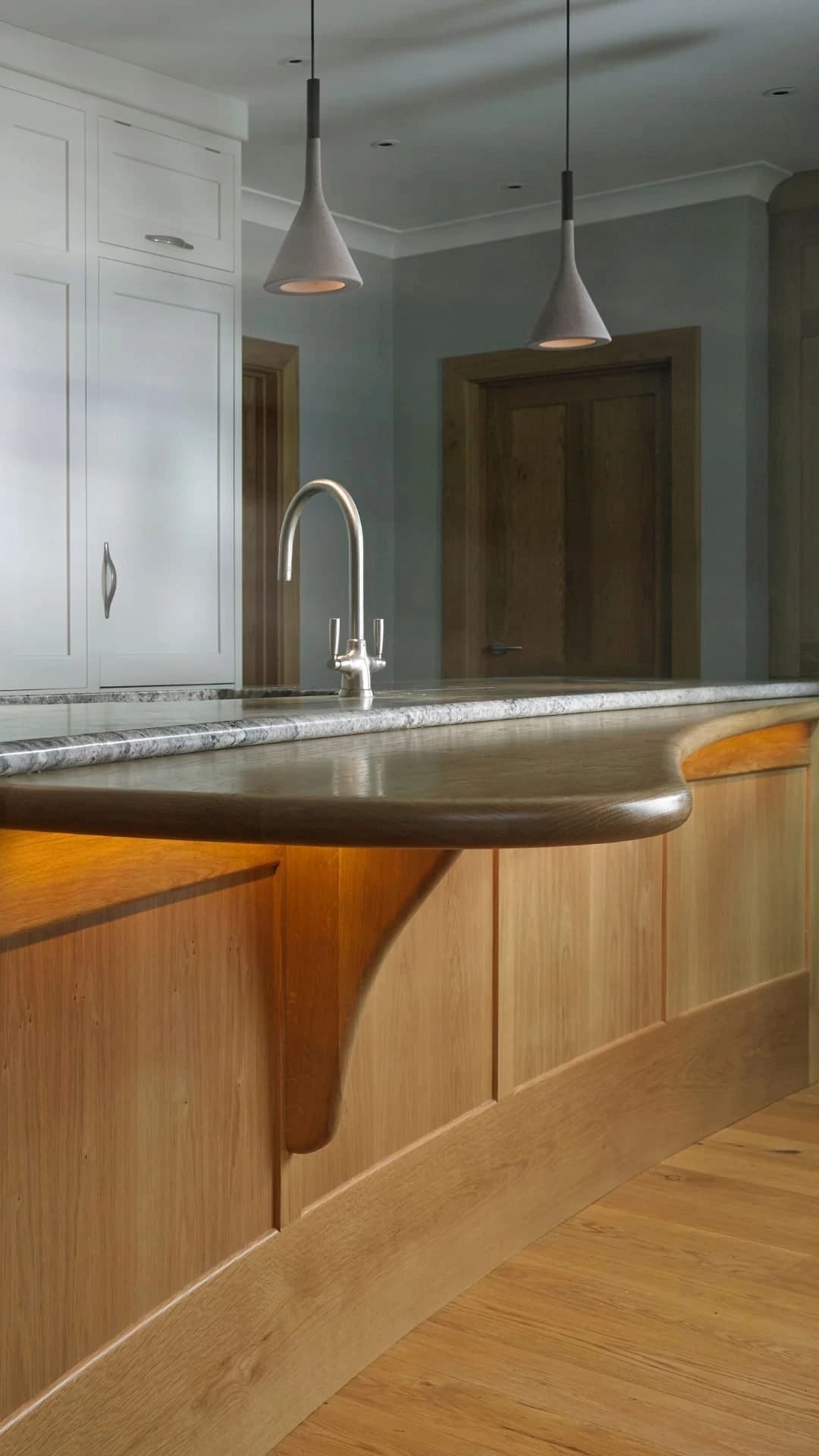Curved timber kitchen island with a metal worktop