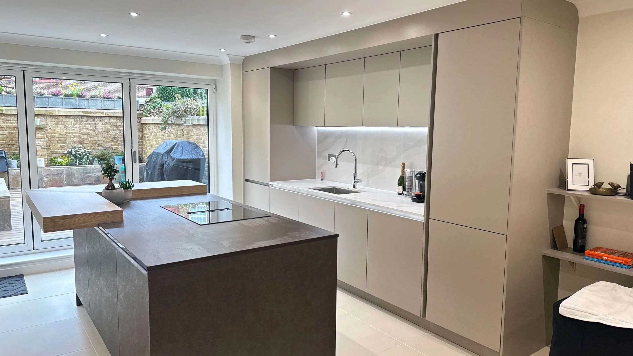 Modern kitchen island with pale cabinetry and garden doors