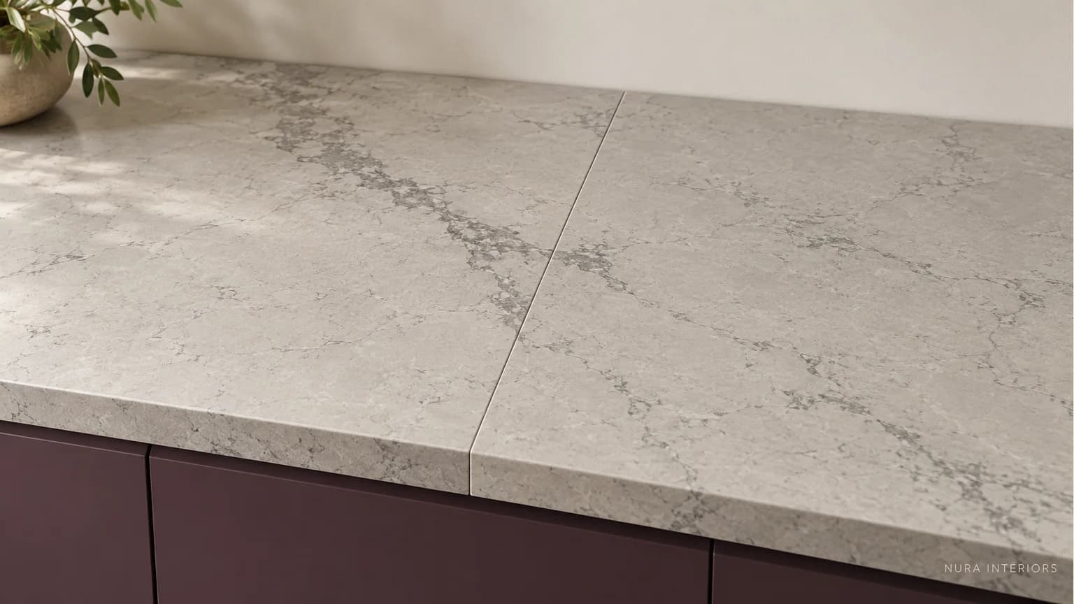 Pale grey worktop sections meeting at a slim visible joint, with grey veining changing across the meeting line.