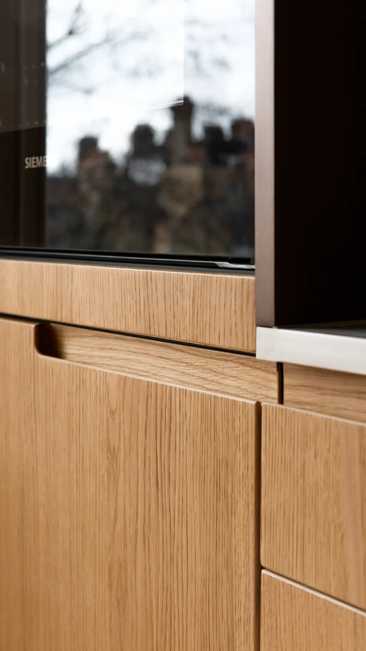 Close-up of timber cabinetry with integrated oven and vertical grain